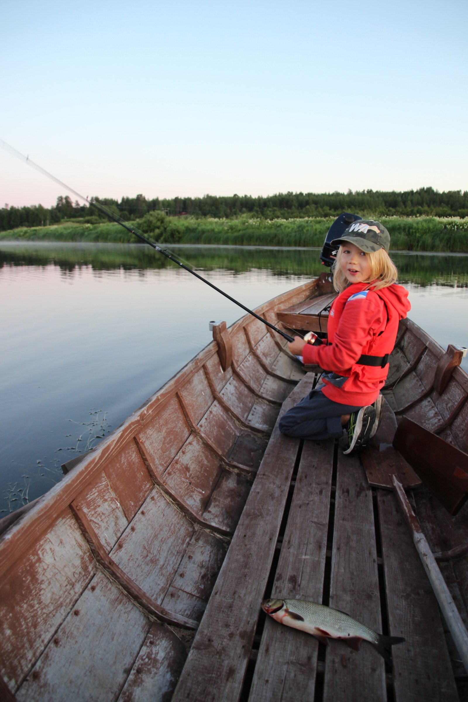 IMG_6575 Lapsi kalastaa jokiveneestä Nivankylässä (c) Piia Juntunen-Laakso 2020